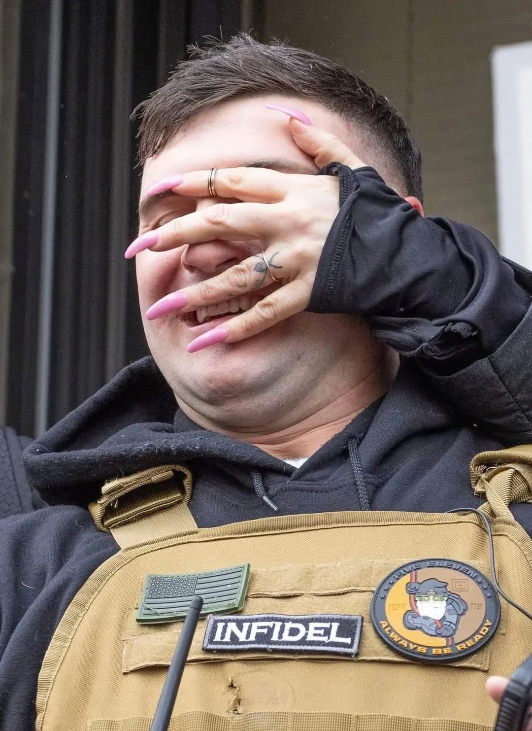 A high femme hand with acrylic nails covers the face of a fascist as he squirms